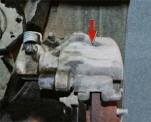Проверьте через отверстие в корпусе тормозной скобы состояние колодок Если толщина фрикционных накладок менее допустимой, замените тормозные колодки