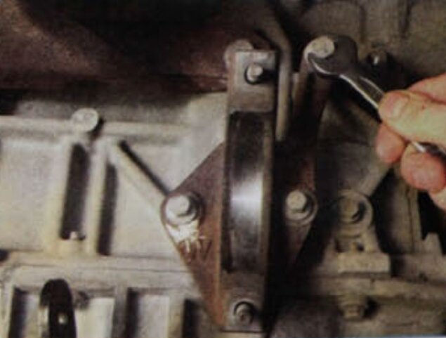 При необходимости выверните три болта крепления кронштейна промежуточной опоры к блоку цилиндров двигателя